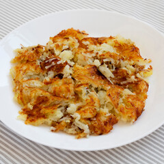 Homemade Fried Hashbrowns on a white plate, low angle view. Close-up.