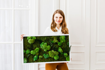 girl holding a picture of moss in her hand, home or office interior decoration