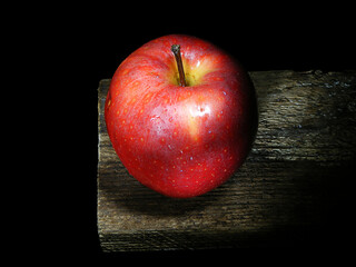 red apple on wooden board isolated on black background
