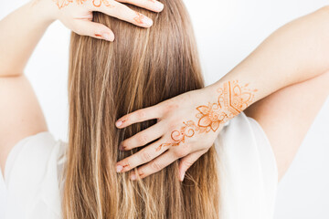 Girl of European appearance, henna drawing on hands, mahendi, girl in light clothes, yoga,...
