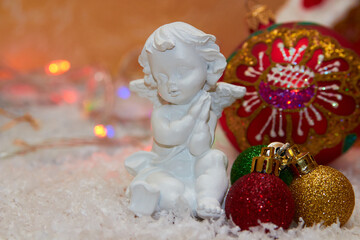 Christmas angel with balls,white little angel decorated for Christmas with snow and balls