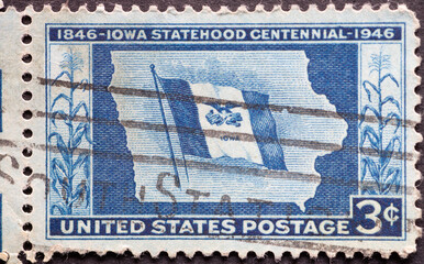 USA - Circa 1946: a postage stamp printed in the US showing the state flag of Iowa in the center and corn stalks on either side. Iowa Centennial