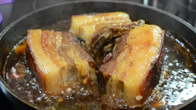 Pork belly fried in sauce in a pan	
