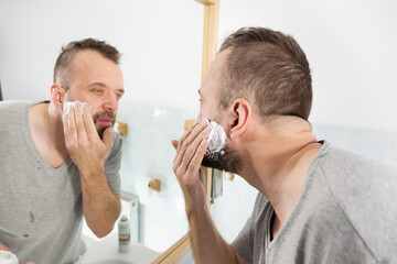 Man applying shaving cream on beard