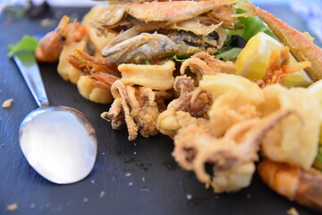 Fish Fry and Salad on Black Background With Spoon 