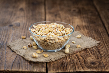 Freshly chopped Hazelnuts on an old wooden table (close up; selective focus)