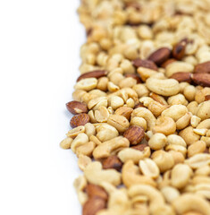 Portion of roasted nuts isolated on white (close up; selective focus)