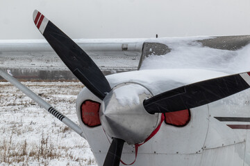 small aircraft with a propeller at the airfield, airport in the snow in winter