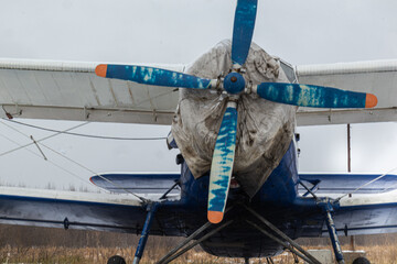 old, vintage plane with a small aircraft propeller at the airfield, airport in the snow in winter