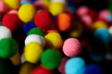 Fototapeta na wymiar Fluffy and colorful litle balls on black background