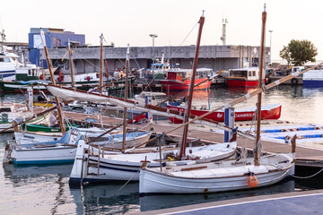Spain; Oct 2020: Traditional sailing boats docked at a harbor. Village by the Mediterranean sea at summer time. Calm sea. Cambrils, Catalonia, Spain