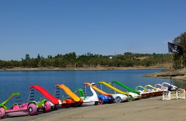 Fototapeta premium Colorful pedal boats on the beach of the Orellana dam, Extremadura - Spain