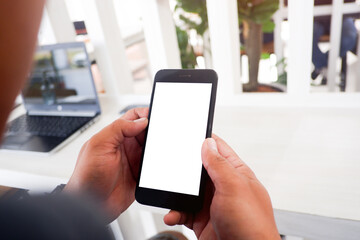 Cropped shot view of woman’s Hands hold or man’s Hands hold the smartphone with blank copy space screen for
your information content or text message on the gray granite at the modern place.