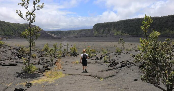 4k locked off stationary motion view of woman walking the Iki trail inside the Kilauea Iki crater, caldera of Kīlauea,Volcanoes National Park,big island,Hawaii,USA