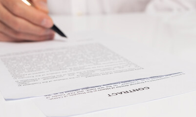 Contract signing concept. close up of male hand putting signature in legal agreement form