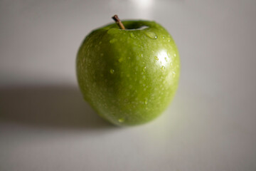 a green apple with drops of water
