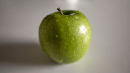 a green apple with drops of water