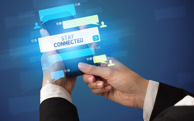 Female hand typing on smartphone with STAY CONNECTED inscription, social networking concept