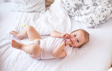 Fototapeta na wymiar little cute girl playing in bed laughing and smiling