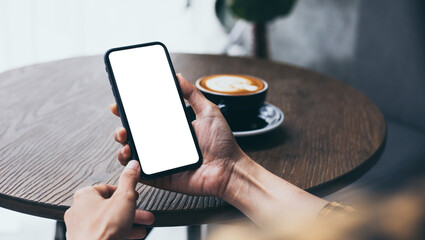 cell phone blank white screen mockup.woman hand holding texting using mobile on desk at coffee shop.background empty space for advertise.work people contact marketing business,technology