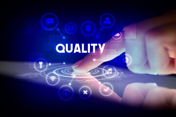 Obraz premium Finger touching tablet with web technology icons and QUALITY inscription, web technology concept
