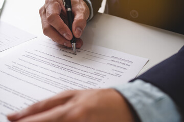 Close up view of hand signing signature on contract of employment job.