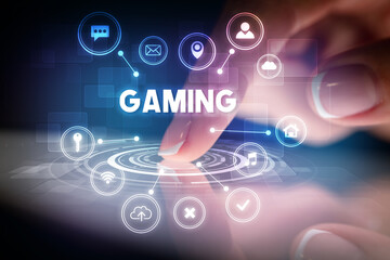 Finger touching tablet with web technology icons and GAMING inscription, web technology concept