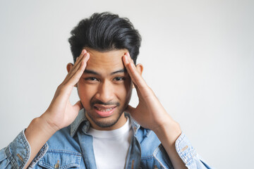 Young man has a strong headache isolated on background.