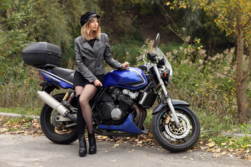 Fototapeta na wymiar Beautiful slim woman sitting on the motorcycle