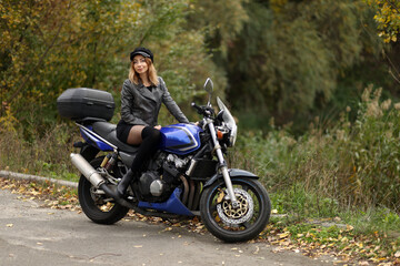 Naklejka na ściany i meble Beautiful slim woman sitting on the motorcycle