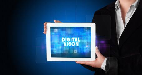 Young business person working on tablet and shows the inscription: DIGITAL VISON