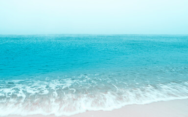 Seascape of blue sea and white sand beach with motion blur waves