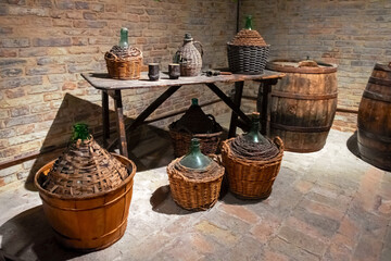 Ancient wine barrels and demijohns in a cellar.