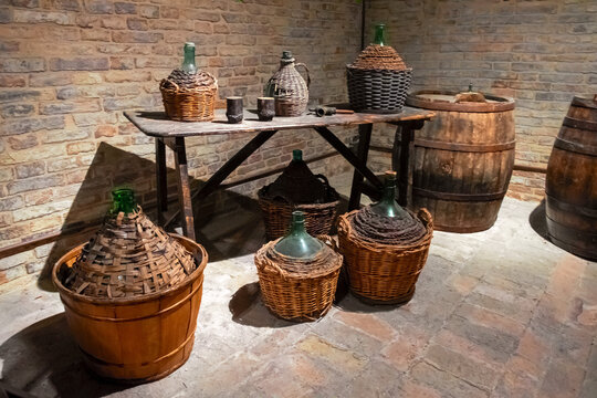 Ancient wine barrels and demijohns in a cellar.