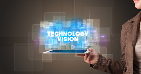 Young business person working on tablet and shows the inscription: TECHNOLOGY VISION