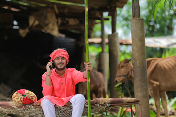 Obraz na płótnie Canvas Young indian farmer talking on mobile phone