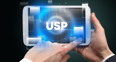 Close-up of a hand holding tablet with USP abbreviation, modern technology concept