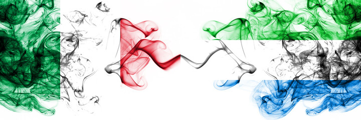 Italy vs Sierra Leone smoky mystic flags placed side by side. Thick colored silky abstract smoke flags