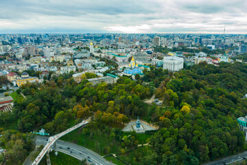 Obraz premium Aerial drone view of new pedestrian cycling park bridge construction, hills, parks and Kyiv cityscape from above, city of Kiev skyline, Ukraine