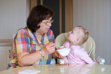 Fototapeta premium General view of the grandmother and granddaughter in the process of feeding