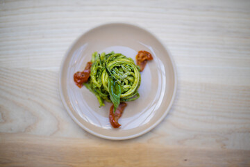Above view of a zucchini noodles and spinach dish on a wooden table