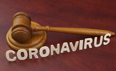 Wooden judge gavel with word coronavirus. Concept of quarantine and law against covid-19.	