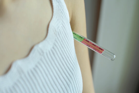 Girl Holds An Armpit Mercury Thermometer. Close-up