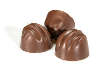 Chocolate pralines. Three dark chocolate bonbons with coffee fillings, macro close-up isolated on white background.