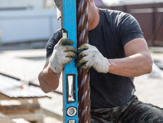 A worker places a metal pole on a level