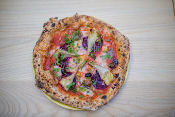 Above view of a thick vegan pizza on a wooden table