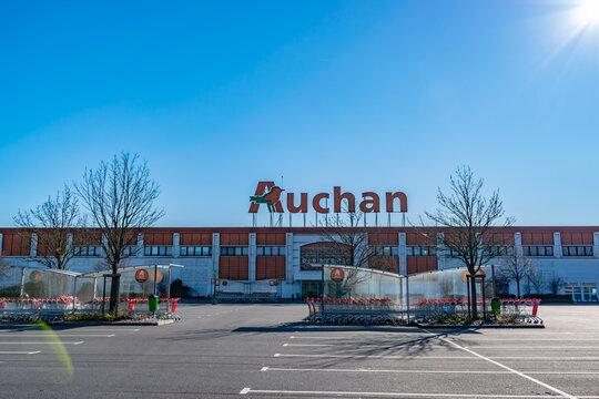 Roncq,FRANCE-February 25,2018: View of Auchan supermarket logo, entrance and parking.Auchan is a French international supermarket chain, is one of the largest distribution groups. 
