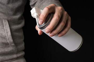 Can with compressed air spray in hand
