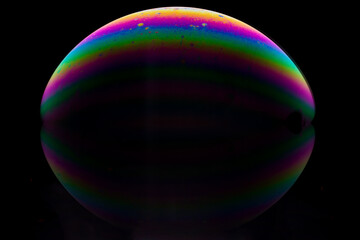 Obraz na płótnie Canvas Half a soap bubble on a black background with reflection