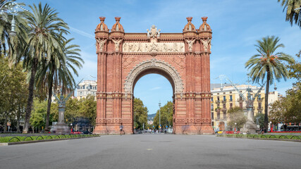 Arc de Triomf (Triumphal arch) in the city of Barcelona in Catalonia, Spain. The arch is built in reddish brickwork in the Neo-Mudejar style. - obrazy, fototapety, plakaty